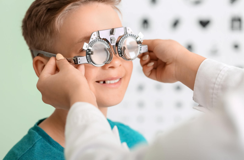 A happy young boy undergoing an eye exam to help determine if orthokeratology is right for him.