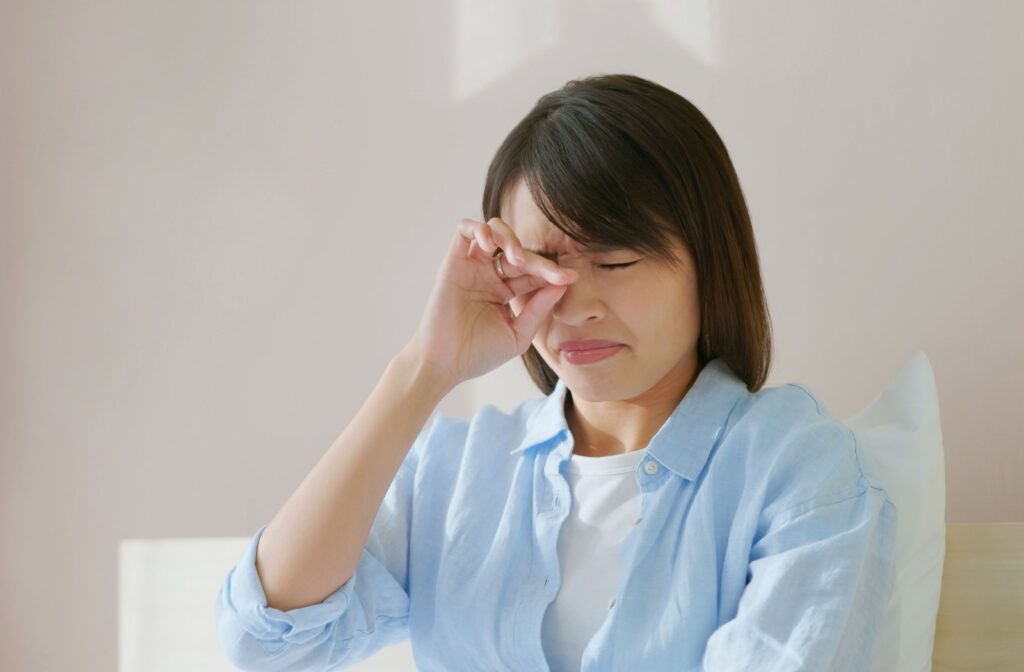 A woman rubbing her eyes due to dry eye disease.