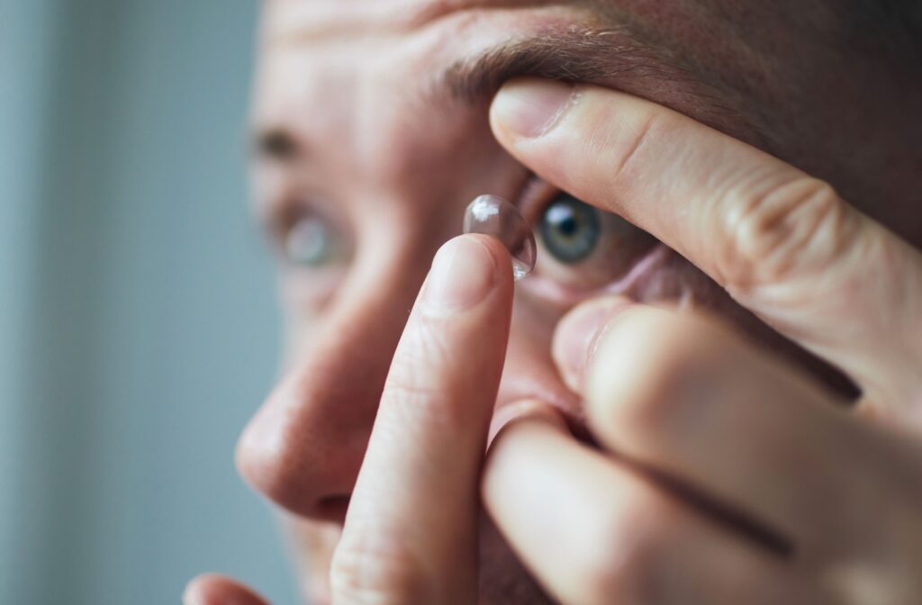 A closeup of a man applying contact lenses.