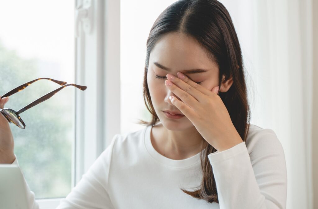 a young woman is rubbing her eyes due to her dry eye symptoms, itching for relief