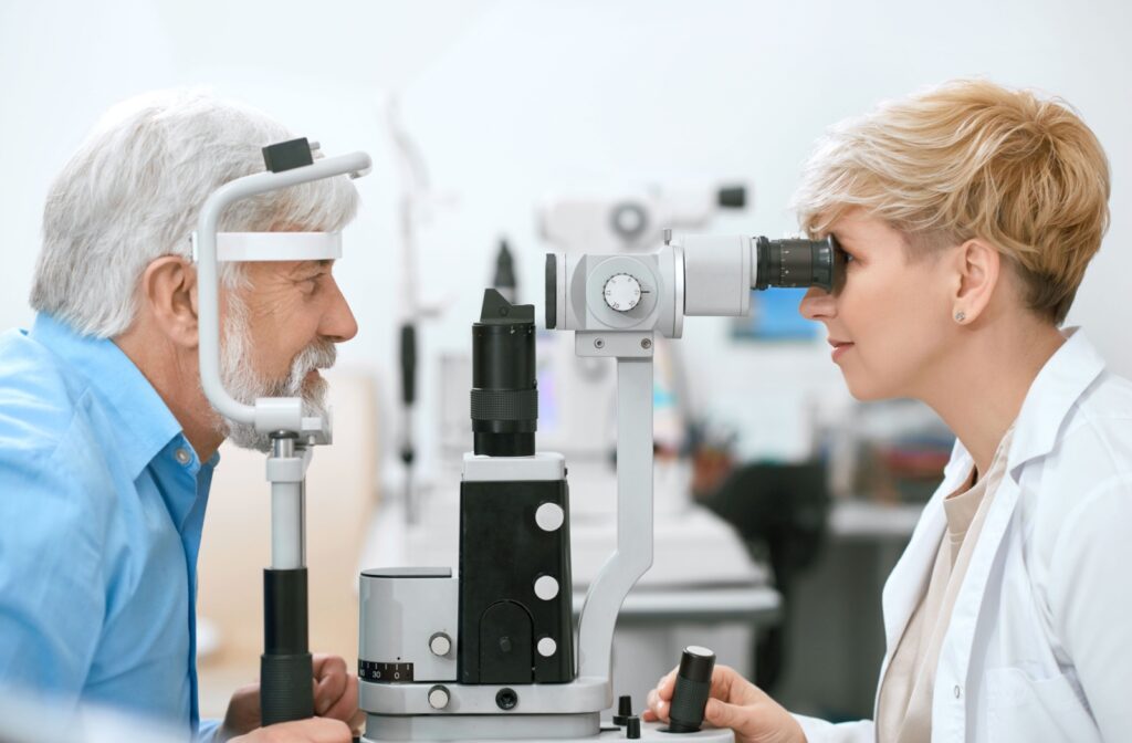 An optometrist examining a male patient's eyes during a laser eye surgery consultation.