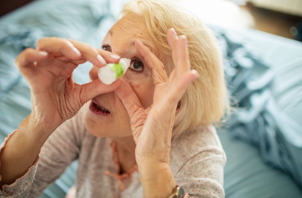 Older woman applying eye drops to relieve dry eyes and blurry vision after waking up