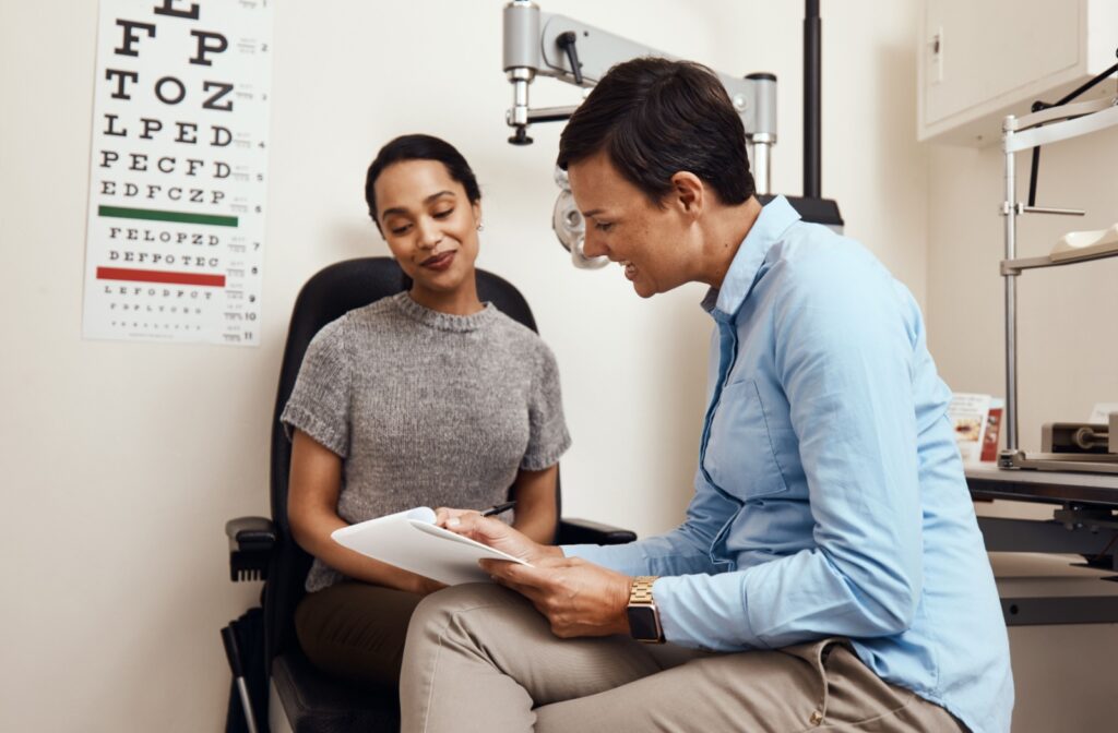 An optometrist sits with their patient and explains the results of their patient's annual eye exam.